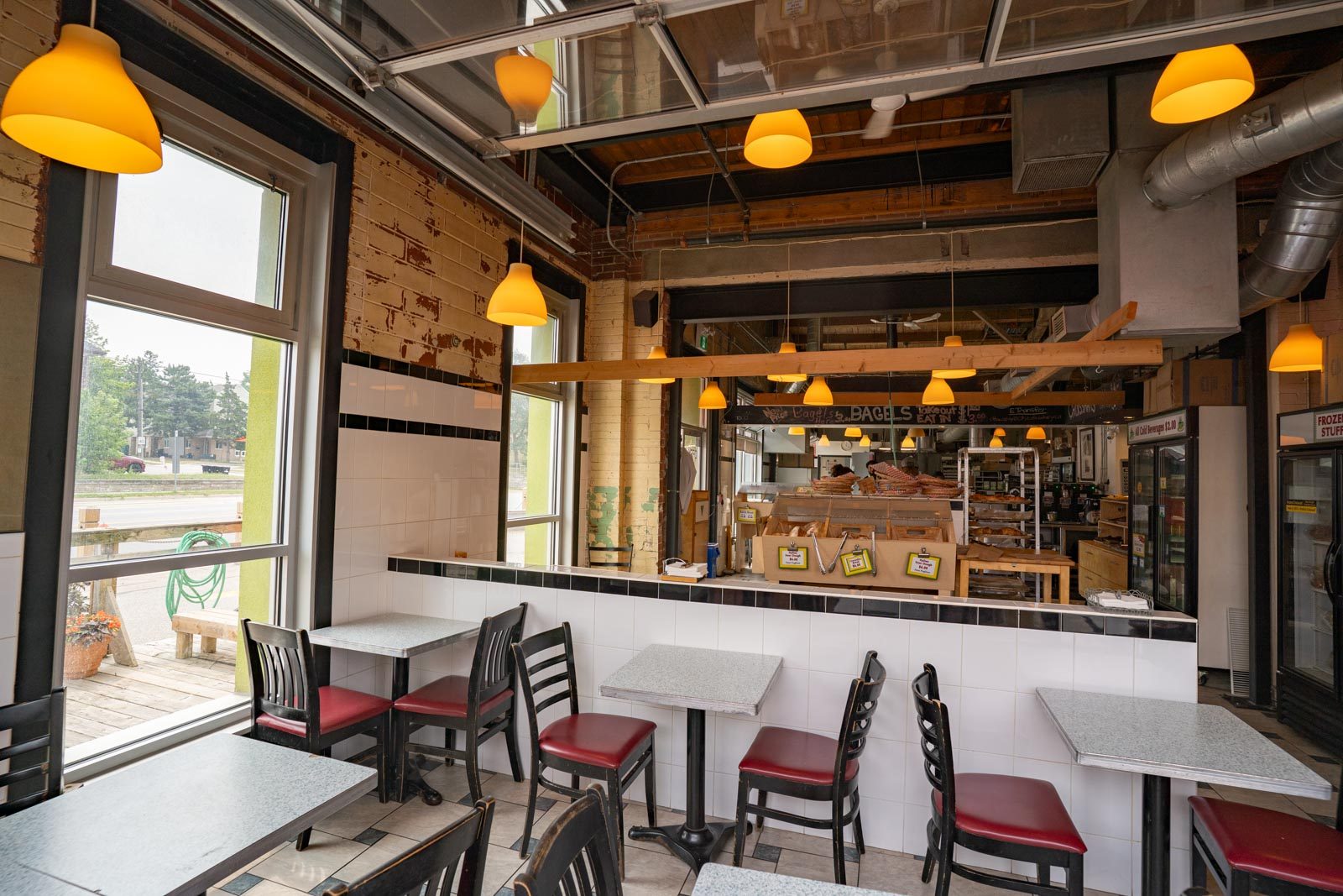 Tables and chairs under warm pendant lights inside the café